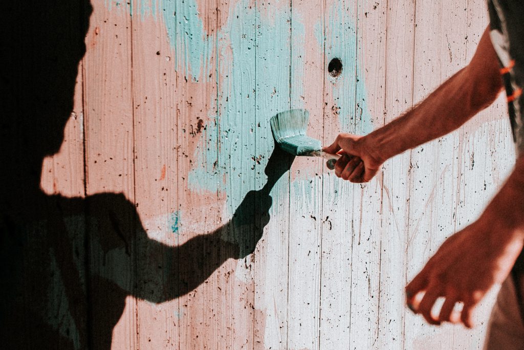 A man paints a red fence with a new blue color. One of the ways in which we can connect with others and build trusting relationships is by serving, or helping, them in a practical way.