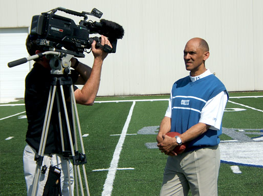 Camera man and Coach Dungy prepare for the next take