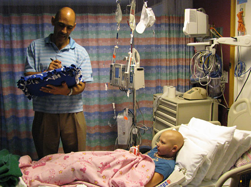 Tony Dungy talking with patient and autographing his pillow