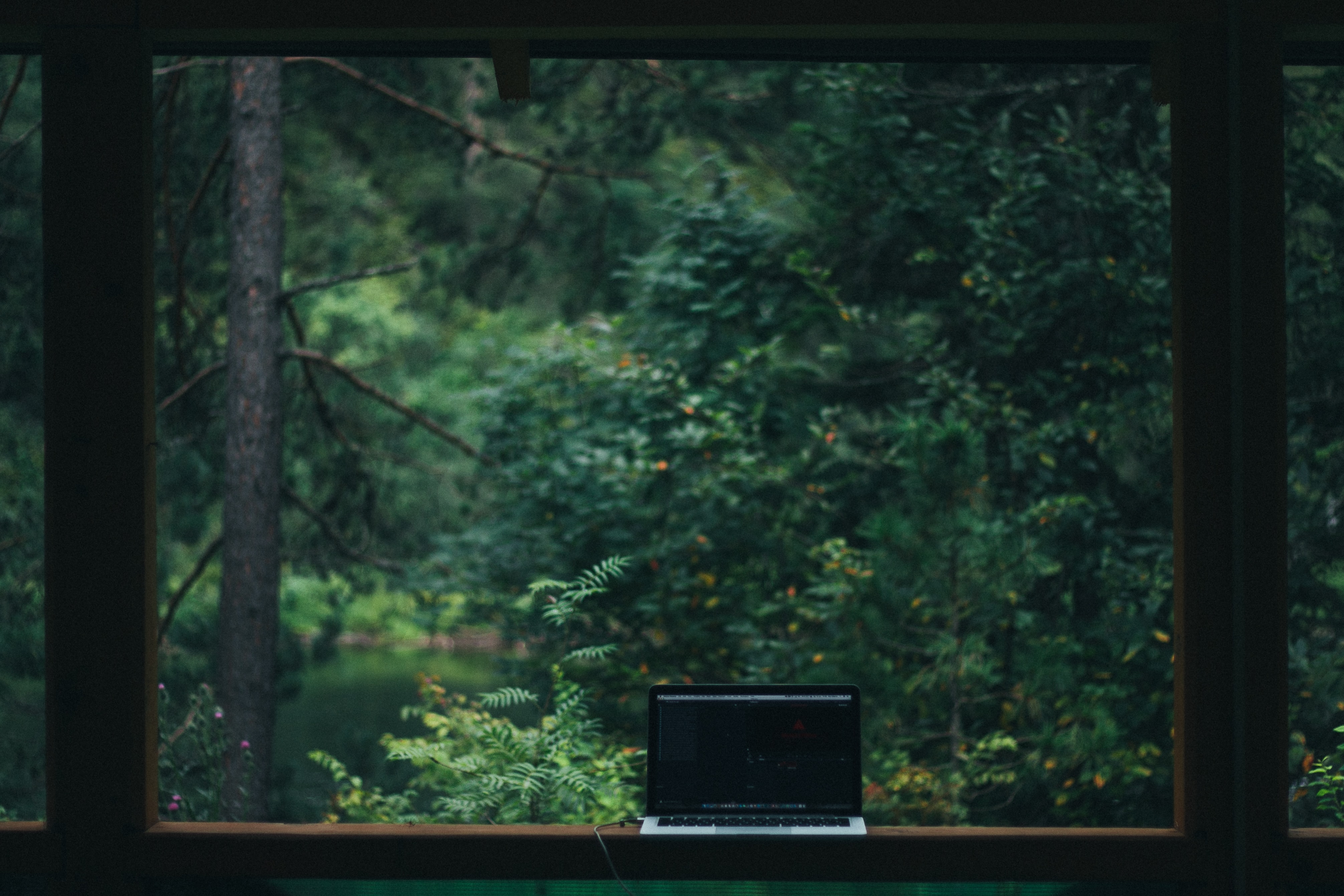 Laptop sitting on window with picturesque view