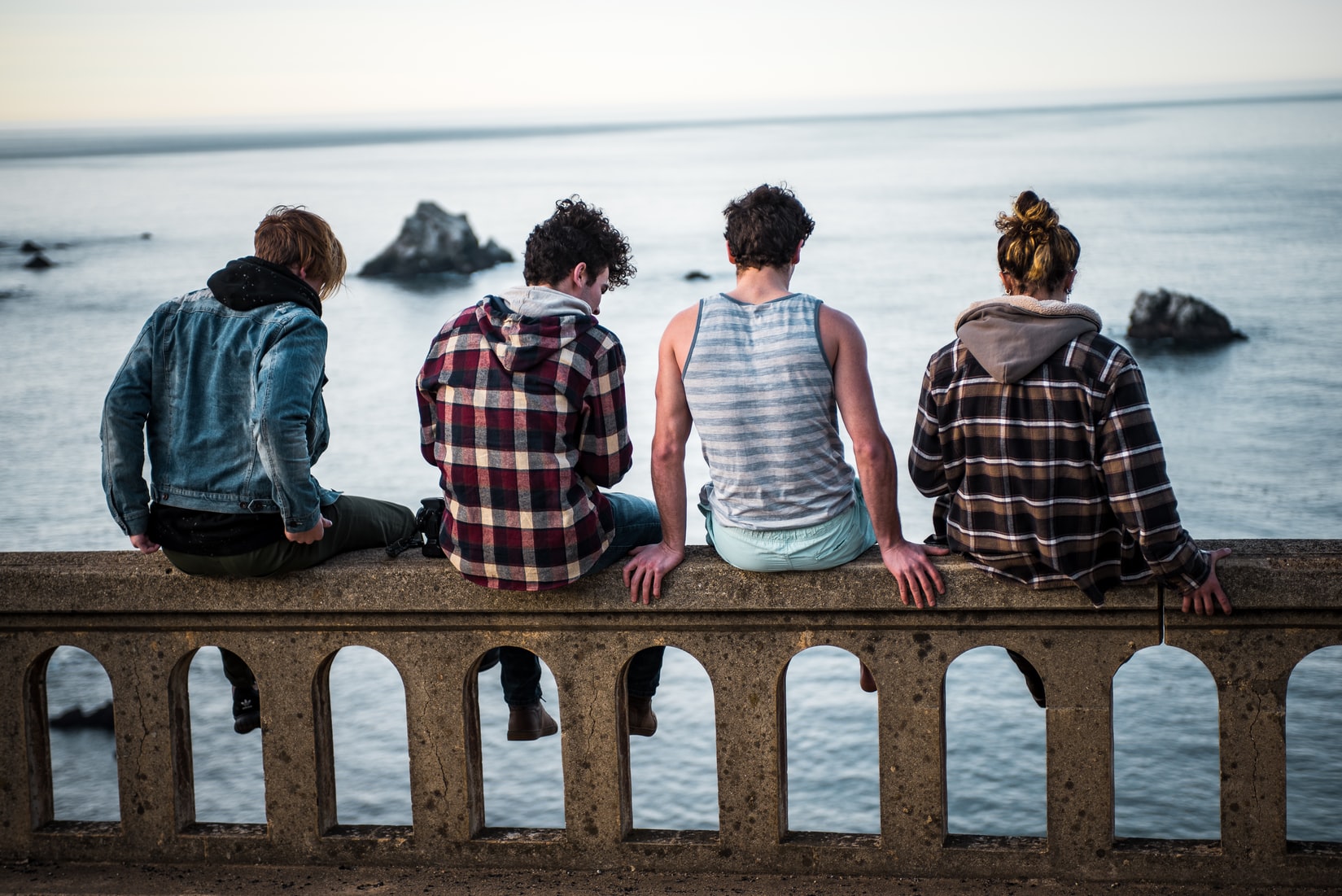 friends sitting by body of water