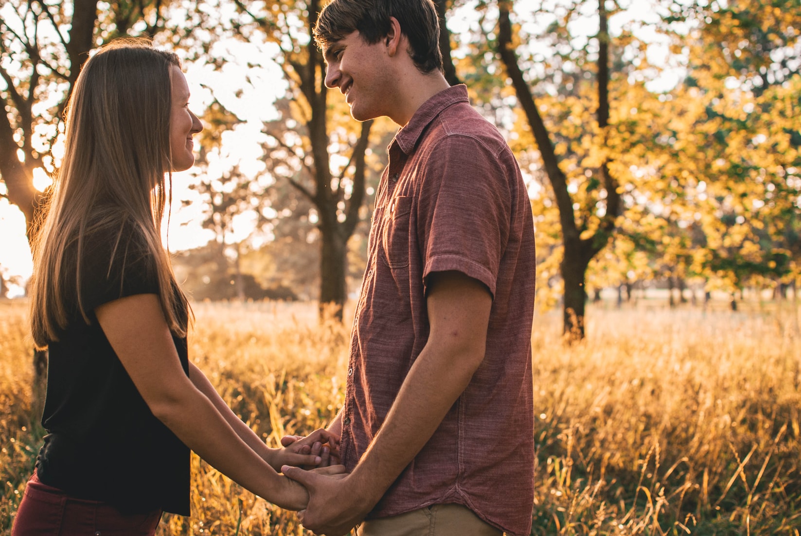 romantic couple holding hands in a forest