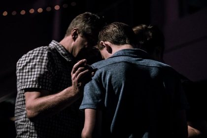 two men praying together at church