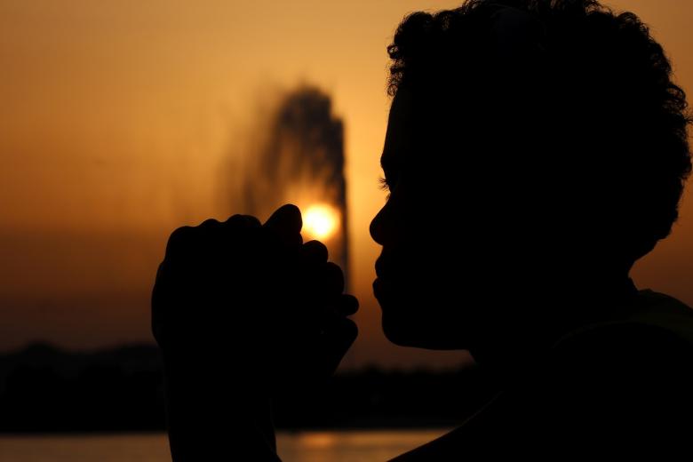 woman praying outside during nighttime