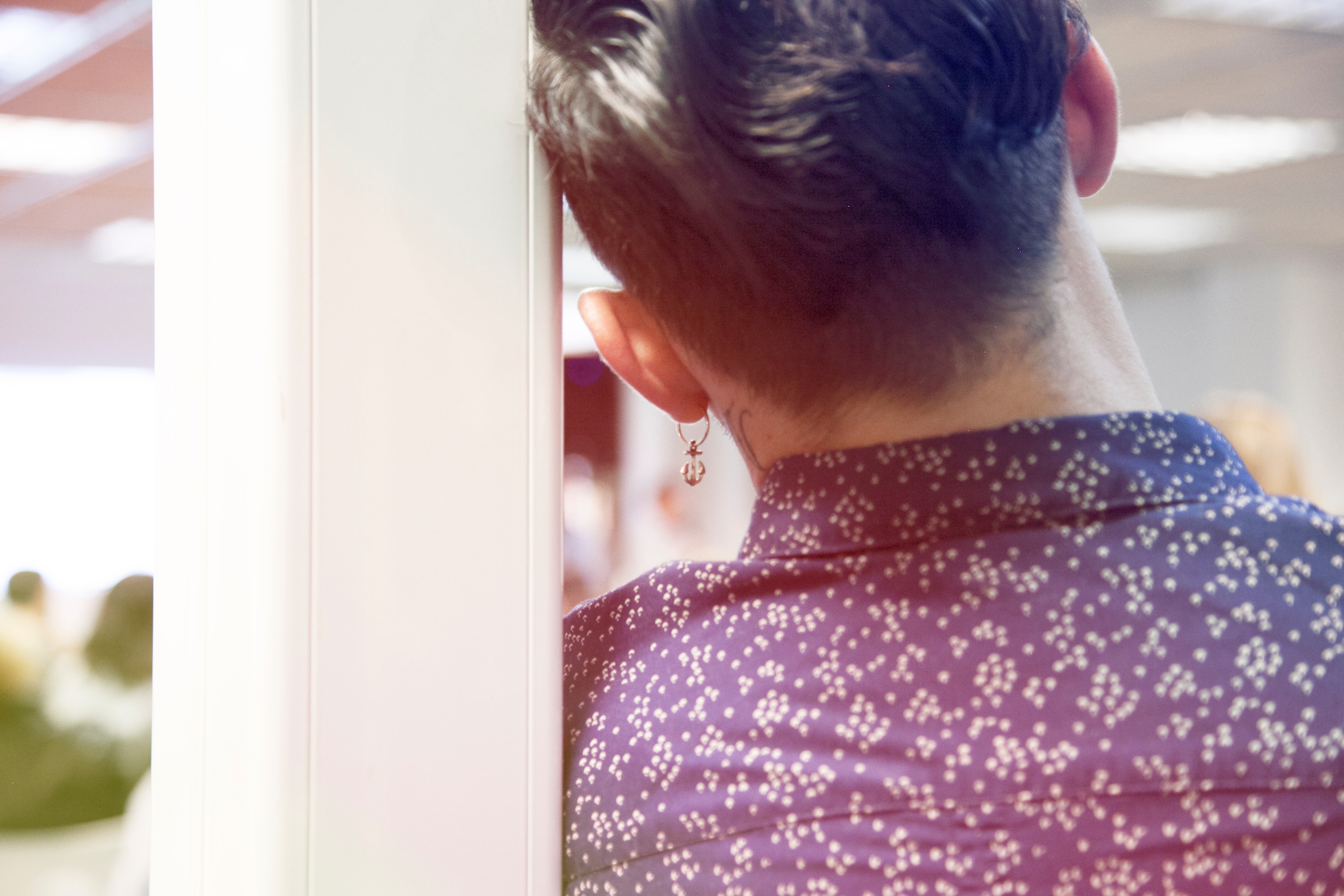 A man with an anchor earring, seen in close up and from behind, leans against a whit plastic pillar in a large room that appears to contain other people sitting down and watching a person on stage. Your non-believing friends will have questions, allow God to answer them. One way of doing this is to direct the question back to them.