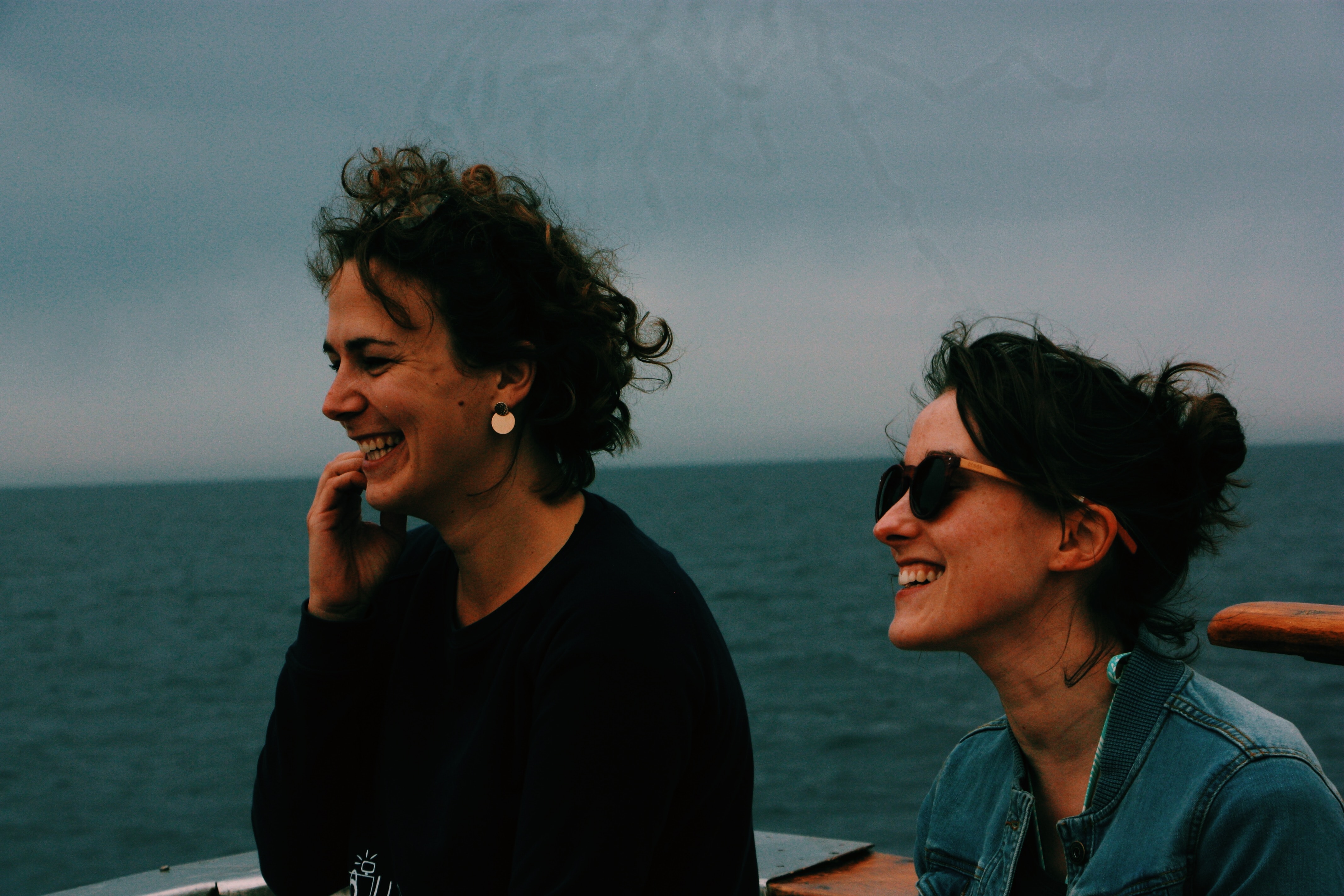 Two women stand smiling on what appears to be a boat on the ocean. How do you casually ask someone to read the Bible with you? This article explores options for inviting non-believing friends.