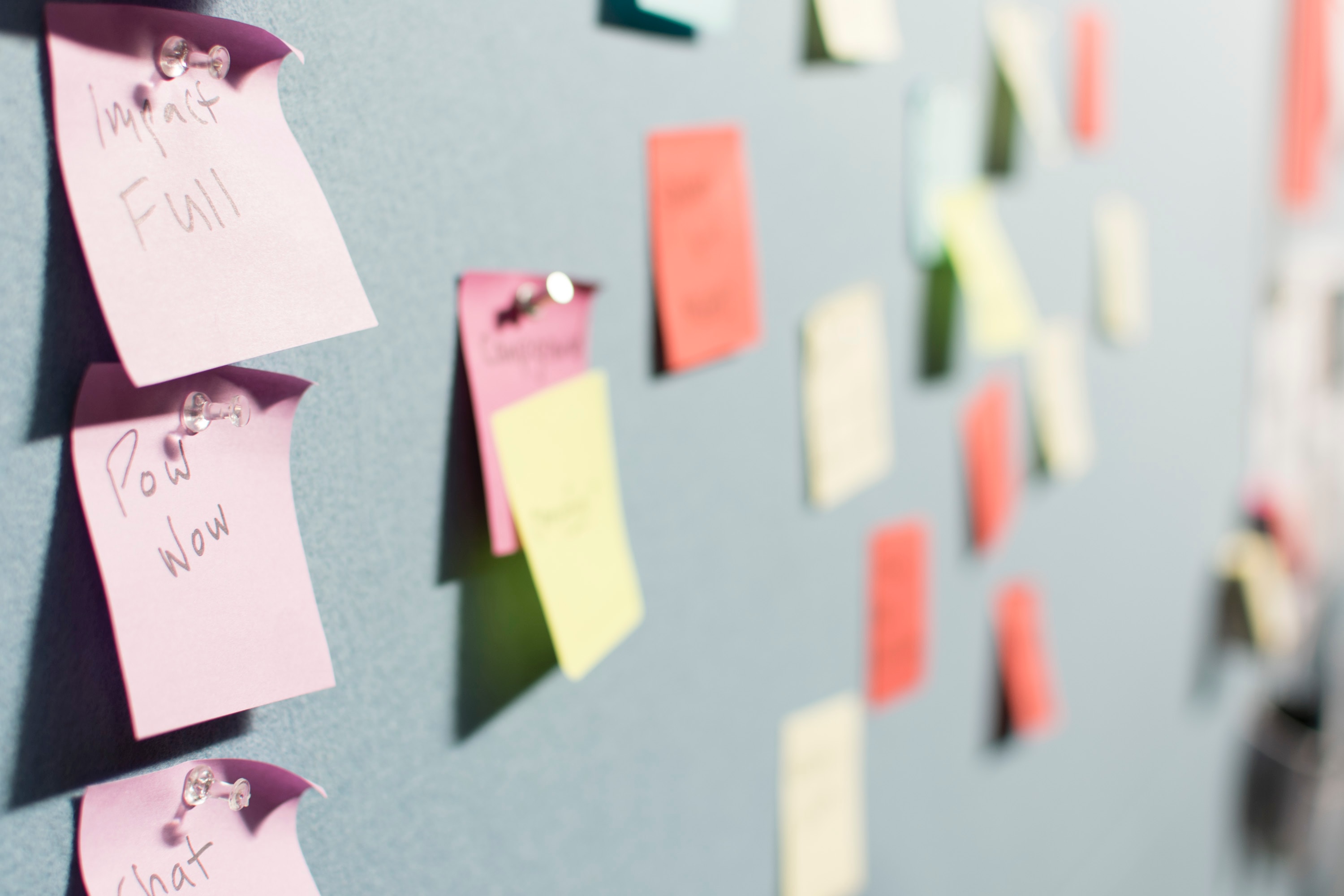 A number of colorful sticky notes are pinned to a wall. Asking questions to reflect back on the Scripture you've just read can help your non-believer friend find the meaning in the Word.