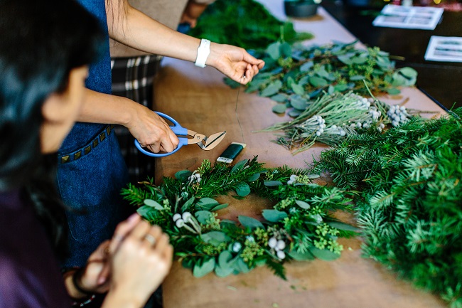 Two people work on wreaths with lush green leaves, crafting beautiful decorations. Matching up your spiritual gifts, with your personality, passions and preferences for format, will lead you to deep joy and you'll be helping to move the Kingdom forward!