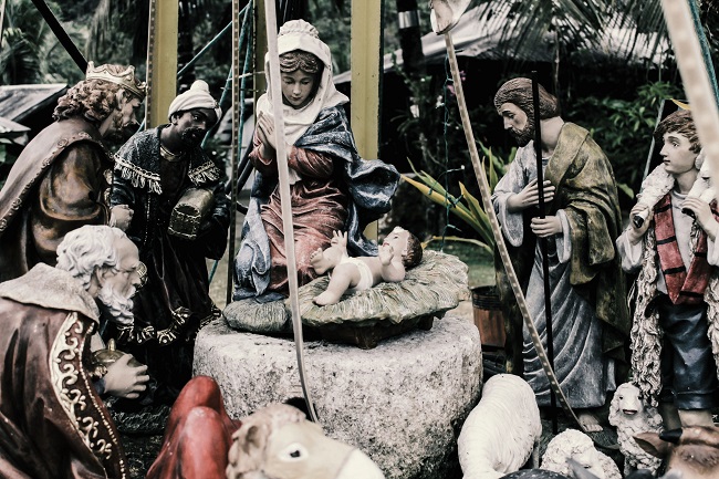 A nativity scene with stones and statues is pictured, with baby Jesus in the center.