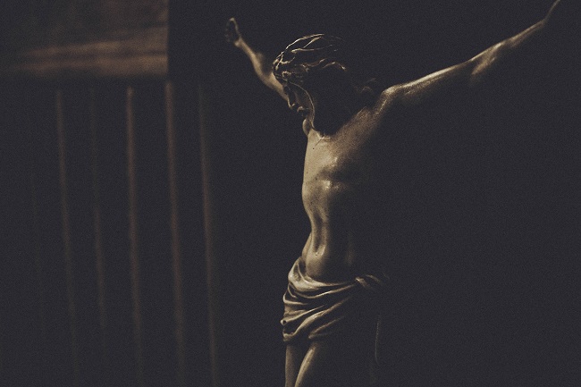 A statue depicts the crucifiction of Jesus. Why would Jesus come to earth knowing that He would have to suffer for us?