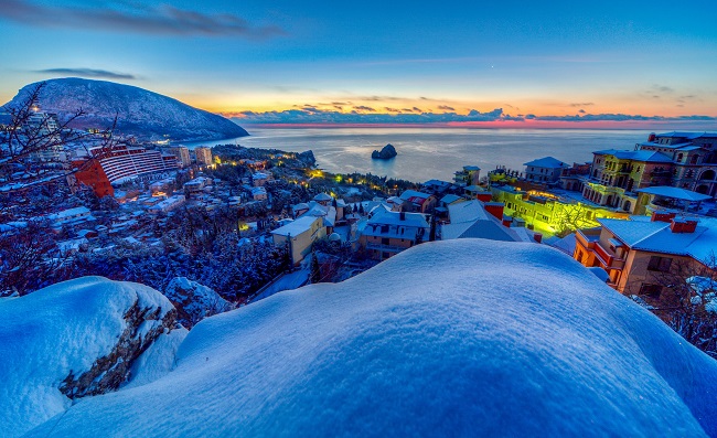 A from a hill view, we see a snowy seaside town, lit by a colorful sunset. Why did Jesus come to earth? HE came to offer us all a hope in eternal life with His Father in heaven.