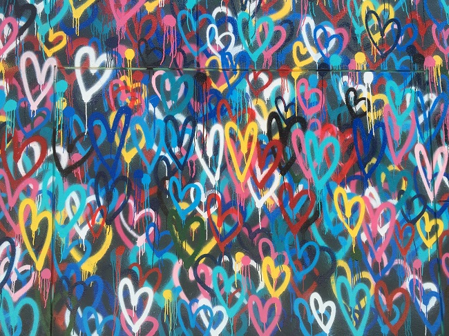 A wall of colorful and joyful graffiti hearts reminds us to be grateful and pray to God with gratitude every day.