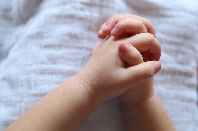 A small child's hands are clasped together in prayer. PRaying to God is so easy, children can do it!