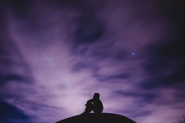 A person is seen in sillouette against a purple night sky. You can talk to God like you would any friend. Prayer doesn't need to be hard or complicated.