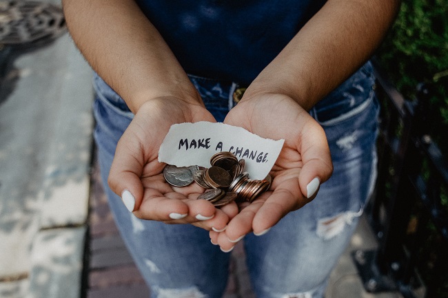 A pair of hands hold out change and a note that says 'make a change'. 