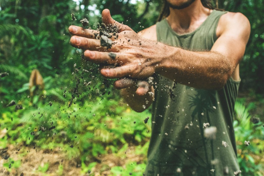 A man wipes his hands of dirt, showing he has worked hard, demonstrating God's love for us all