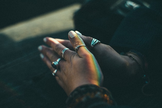 Hands clasped in prayer with rings on all the fingers. How to pray and get results, just start praying and listening.