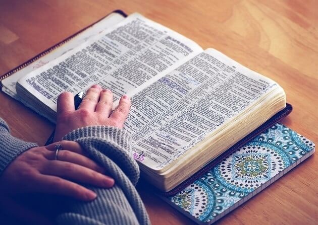 Person reading their Bible with a pen in hand. Encouraging Quiet time.