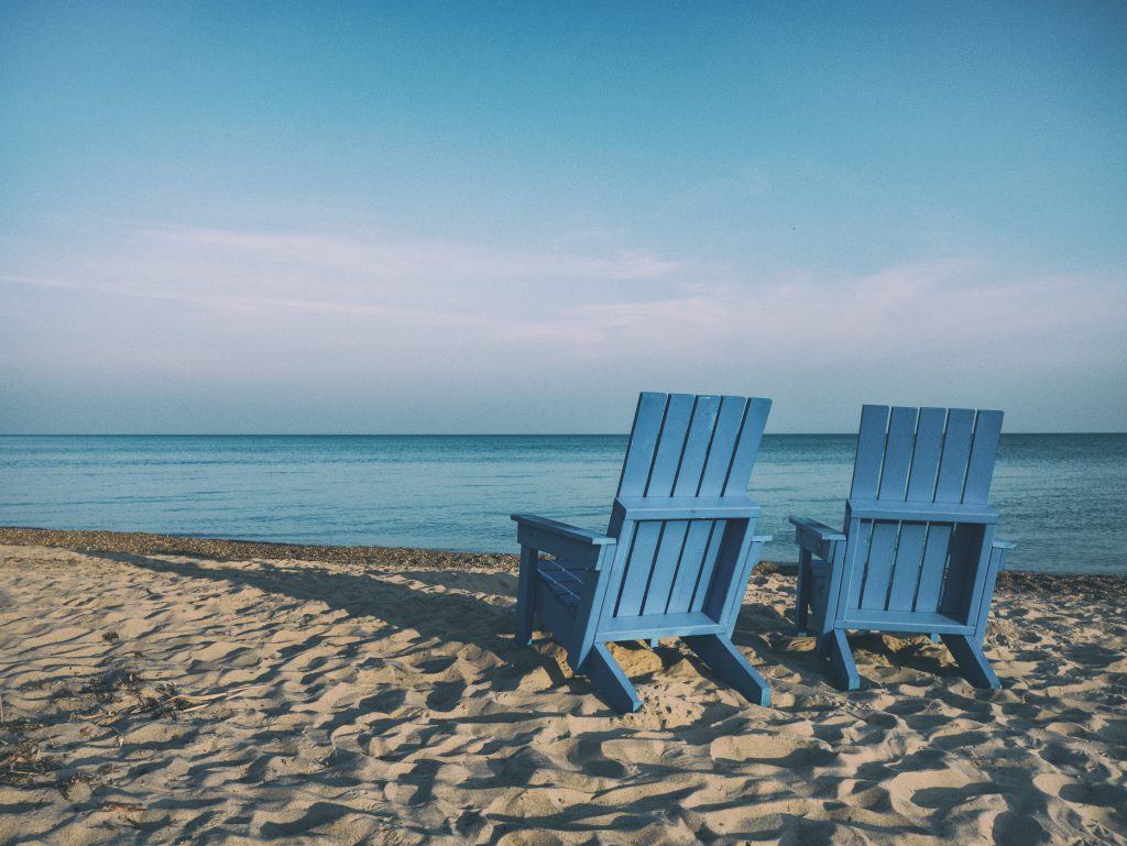 Empty beach chairs as the sun gets low behind them. Talk about your testimony with others.