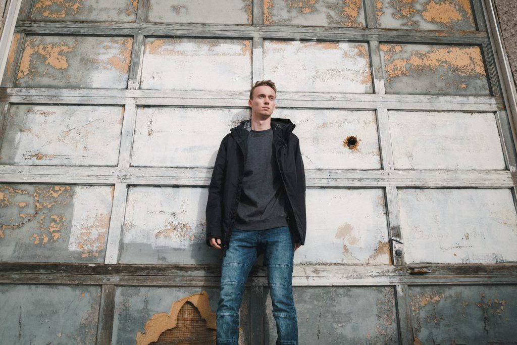 How Can I Stop Sinning? A Young man stands before a damaged wall, looking pensive.