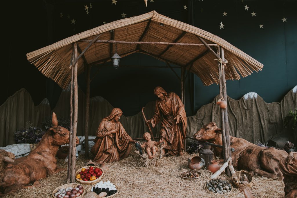 Image of the nativity made in wood, with Mary, Joseph and Jesus Christ in a stable surrounded by gifts and animals. A traditional image of Christmas as we celebrate as new believers.