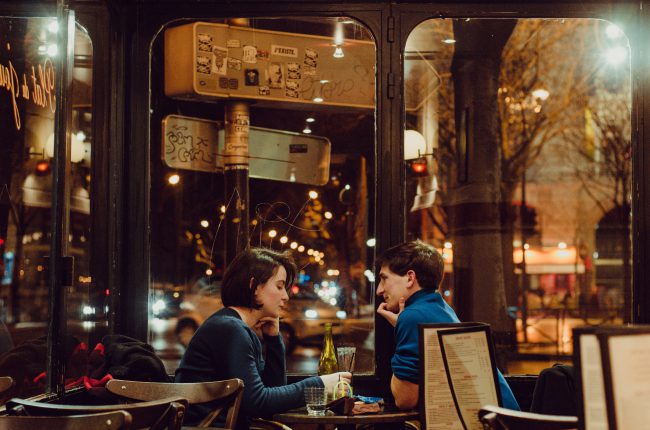 A man and a woman talk in a cafe at night. It looks a little tense. By forgiving others in your life, you free up your heart to be more open to God.