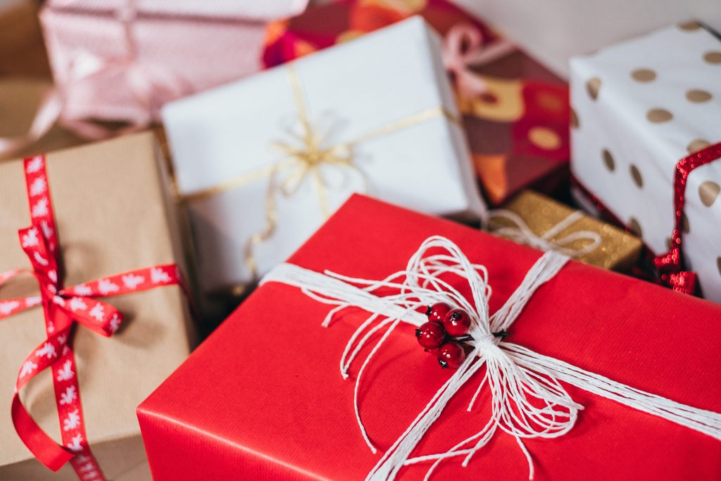 A pile of red white and gold wrapped Christmas presents tied with various string and ribbons. Which real gift of faith can you be giving this Christmas?