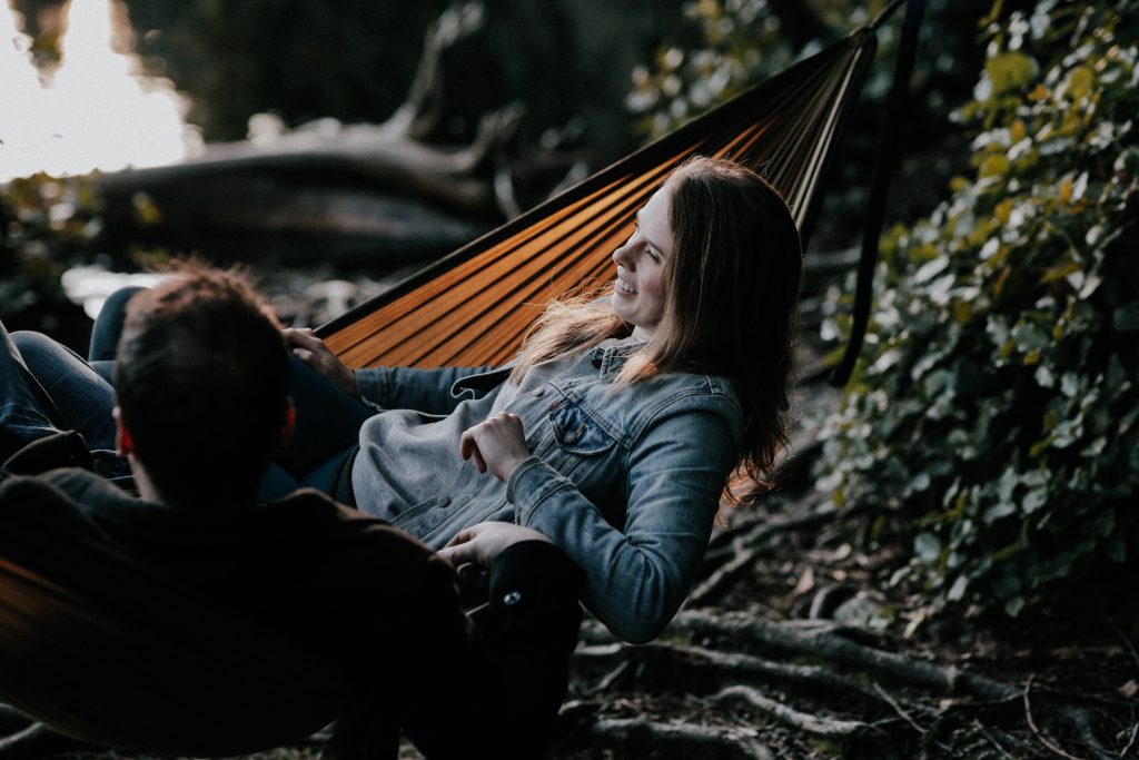 A young woman happily lounges in a hammock while chatting with a man surrounded by woodland. Thinking about your relationship with Jesus, how can that help you to start relying on God's promises?